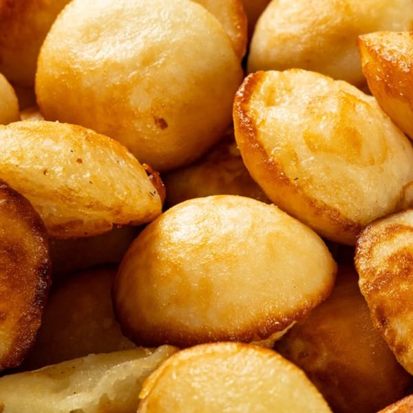 Close-up of golden brown fried dough balls, a popular African delicacy, from Lynda's African Delicacies.